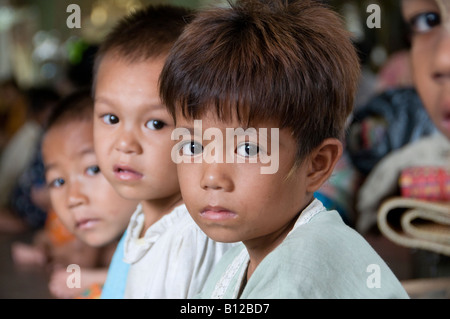 I bambini sfollati in un monastero buddista assylum offrendo alle persone colpite dal ciclone Nargis vicino a Yangon. Myanmar Birmania. Foto Stock