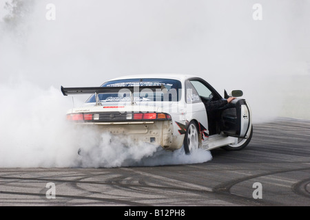 La deriva australiano Motorsport concorrente esegue una celebrazione burnout nel suo modificato Nissan 200SX dopo aver vinto un evento di deriva Foto Stock