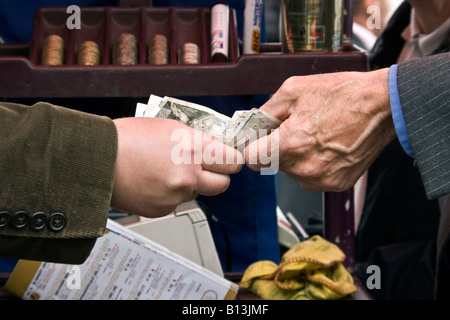 Primo piano di due mani lo scambio di denaro presso l'ippodromo bookmakers in Perth Scozia, Regno Unito Foto Stock