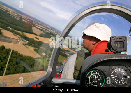 Pilota di parapendio controllo per altri aeromobili con ariel viste di un paesaggio rurale su un luminoso giorno di sole Foto Stock