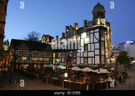 Città di Manchester, Inghilterra. Vista notturna di visitatori gustando uno snack a pranzo presso il vecchio Wellington Inn and oyster bar. Foto Stock