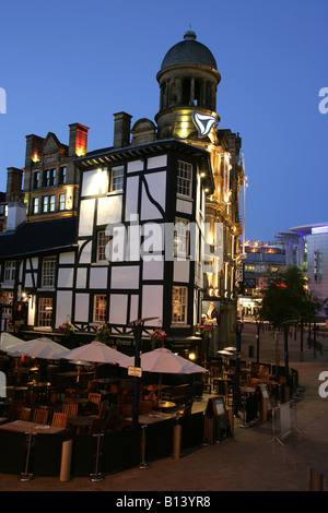 Città di Manchester, Inghilterra. Vista notturna di visitatori gustando uno snack a pranzo presso il vecchio Wellington Inn and oyster bar. Foto Stock