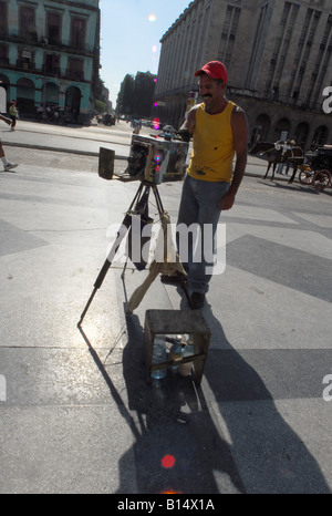 Fotografo di strada prendendo il foro del perno di immagini di telecamera per i turisti al di fuori del Capitolo edificio in Avana, Cub Foto Stock