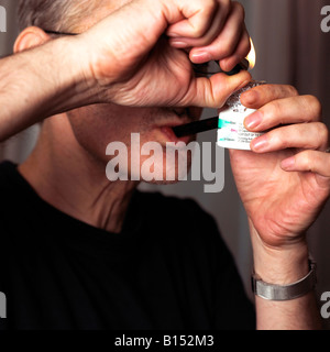 Uomo di fumare cocaina crack da un tubo Foto Stock