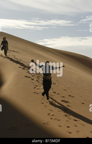 Tourist giocando in dune del Tassili Ahaggar deserto del Sahara AlgeriaOued Tin Tarabine Foto Stock