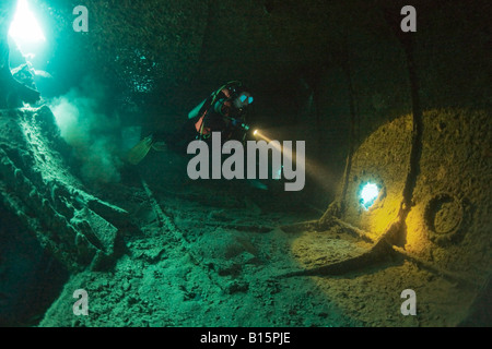 Un subacqueo risplende la sua torcia in un vuoto in attesa di WW2 SS Thistlegorm naufragio nello Stretto di Gubal, Mar Rosso, Egitto. Foto Stock