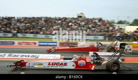 Top Fuel Dragsters pilotato da Andy Carter (nearside). Santa Pod raceway England Regno Unito. Foto Stock