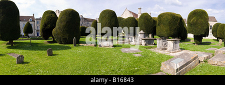 Pietra scolpita tombe e alcuni dei 99 yew alberi nel cimitero del villaggio Costwold di Painswick, Gloucestershire Foto Stock