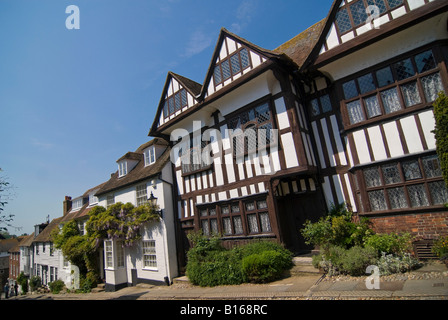 Orizzontale di un ampio angolo di visione del tradizionale Tudor cottages lungo una strada a ciottoli nel pittoresco antico segale su una luminosa giornata di sole. Foto Stock