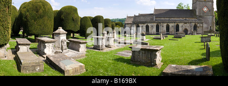 Pietra scolpita tombe e alcuni dei 99 yew alberi nel cimitero del villaggio Costwold di Painswick, Gloucestershire Foto Stock