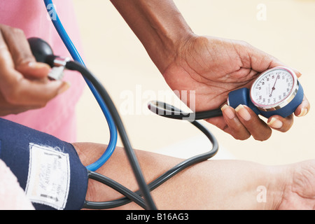 L'infermiera prendere senior della pressione del sangue Foto Stock