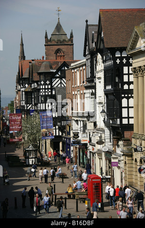 Città di Chester, Inghilterra. Vista in elevazione dei negozi e dello shopping su Eastgate Street verso Chester della Croce alta. Foto Stock