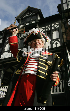 Città di Chester, Inghilterra. Basso angolo di visualizzazione di Chester's Town Crier con il Bridge Street righe in background. Foto Stock