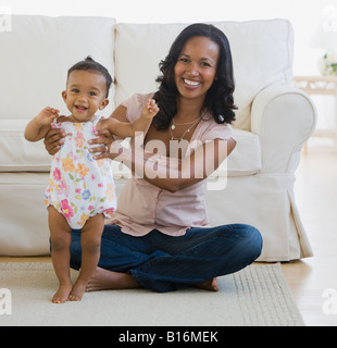 African American madre aiutare baby stand Foto Stock