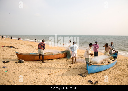 I pescatori e barche di pescatori sulla spiaggia di Ullal a Managlore, Karnataka. Il mare Arabico è piacevolmente caldo nel sole del tardo pomeriggio Foto Stock