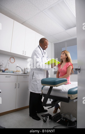 Americano africano medico maschio parlando al paziente Foto Stock