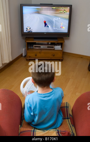 Ragazzo giocando con il Nintendo Wii e ruota il gioco Mariokart Foto Stock