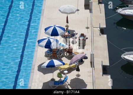 Opatija Istria Croazia Europa può guardare giù sul per vacanza a prendere il sole sotto gli ombrelloni in lato di una piscina Foto Stock