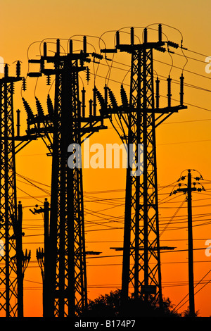 Settore energia / elettricità. Una tensione alta torre di trasmissione stagliano al tramonto. Foto Stock