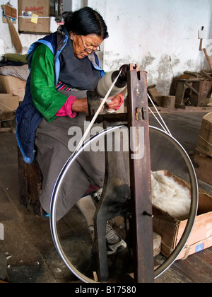 Donna tibetana la filatura della lana Foto Stock