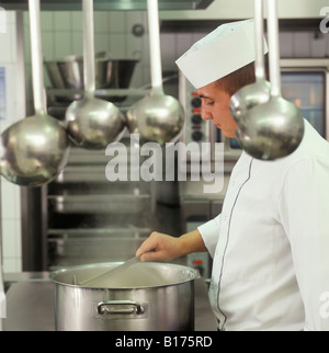 Cuocere mescolando in una pentola, mensa cucina, siviera davanti, Germania Foto Stock