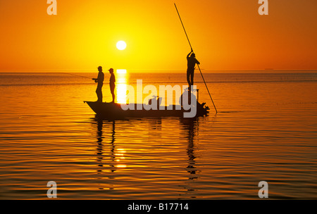 I pescatori fly cast di grandi mosche artificiali per bonefish in acque poco profonde della Florida Keys al tramonto Foto Stock