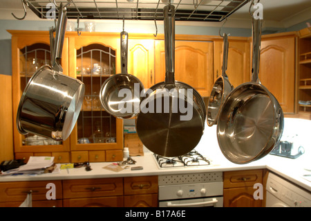 Un gruppo di acciaio inossidabile pentole, padelle e di filtri appesi in  una cucina commerciale Foto stock - Alamy