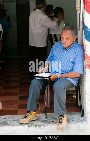 Uomo al di fuori di Barber shop s Merida capitale dello stato dello Yucatan Messico la prima città spagnola costruito in questa parte del Messico Foto Stock