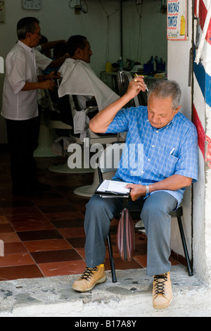 Uomo al di fuori di Barber shop s Merida capitale dello stato dello Yucatan Messico la prima città spagnola costruito in questa parte del Messico Foto Stock