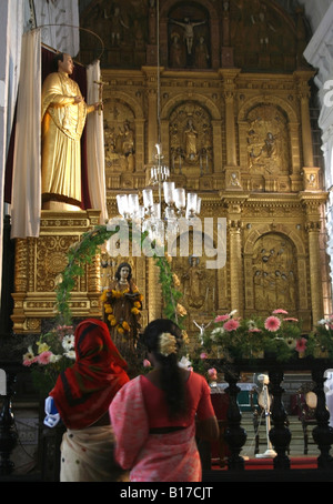 I cristiani indiani culto all'altare maggiore del Duomo Se raffigurante il martirio di Santa Caterina , Old Velha Goa , India Foto Stock