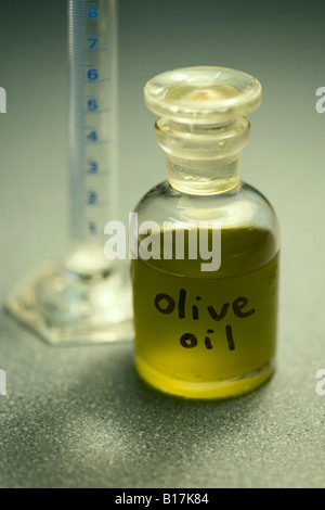 L' olio d' oliva in piccola bottiglia di vetro campione prelevato da coltivazione biologica di alberi in Nuova Zelanda Foto Stock