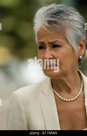 Senior donna ispanica perle da indossare Foto Stock