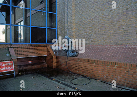 Consiglio lavoratore spray di pulizia escrementi di piccione dalla costruzione di Greenwich Londra Inghilterra REGNO UNITO Foto Stock