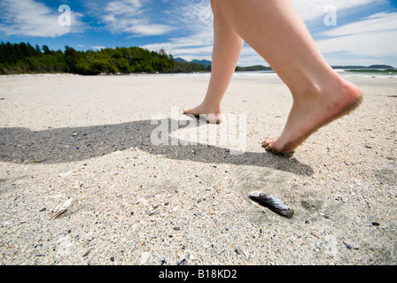 Una donna cammina sulla spiaggia di Vargas isola a Clayoquot Sound vicino a Tofino, British Columbia, Canada. Foto Stock