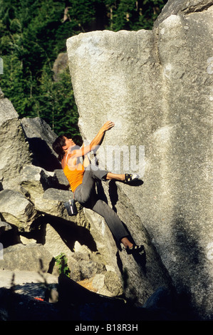 Donna bouldering sul cranio di gabbiano, V6, il grembiule di massi, Squamish, British Columbia, Canada. Foto Stock