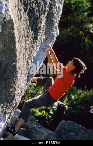 Donna bouldering sul cranio di gabbiano, V6, il grembiule di massi, Squamish, British Columbia, Canada. Foto Stock