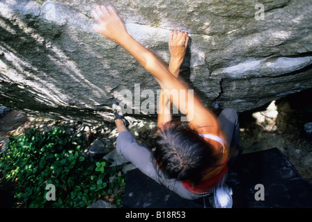 Donna bouldering su Siddharta, V10, il grembiule di massi, Squamish, British Columbia, Canada. Foto Stock