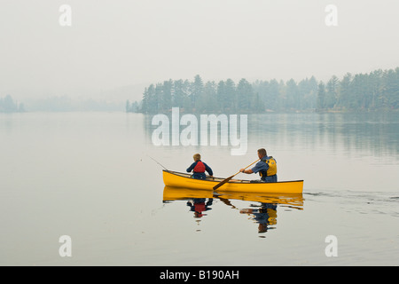 Giovani/uomo di mezza età andare a pesca con il figlio sul lago di origine, Algonquin Provincial Park, Ontario, Canada. Foto Stock
