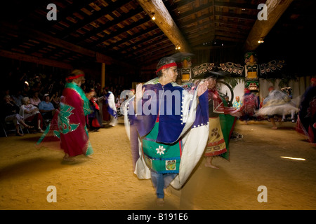 Danzatori provenienti da la banda Komox danza per il pubblico nella loro longhouse in Comox, Isola di Vancouver, British Columbia, Canada. Foto Stock