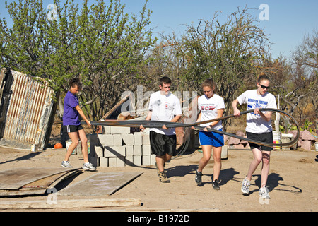 Messico La Paz Senior high chiesa della gioventù gruppo missioni estate viaggio progetto di costruzione spostare i pezzi lunghi di barra di rinforzo Foto Stock