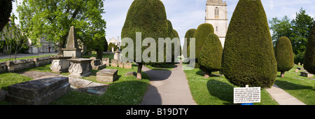 Pietra scolpita tombe e alcuni dei 99 yew alberi nel cimitero del villaggio Costwold di Painswick, Gloucestershire Foto Stock