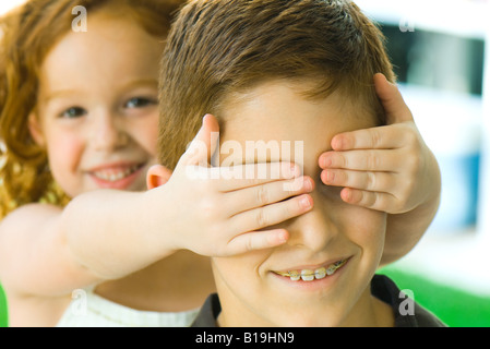 Ragazza tenendo le mani sul grande fratello agli occhi, close-up Foto Stock