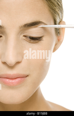 Donna applicazione di make-up occhi, guardando in basso vista ritagliata Foto Stock