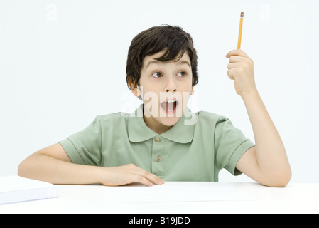 Ragazzo eccitato tenendo in mano una matita, la bocca aperta Foto Stock
