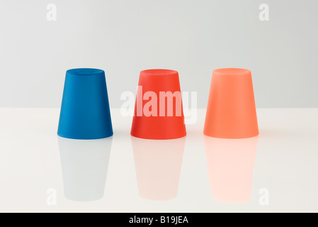 Tre tazze colorate, capovolto Foto Stock