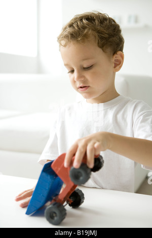 Little Boy giocando con il giocattolo autocarro con pianale di scarico Foto Stock