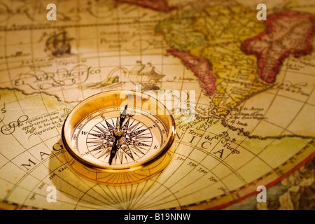 Un oro antico compass impostato su di un sedicesimo secolo mappa del mondo Foto Stock