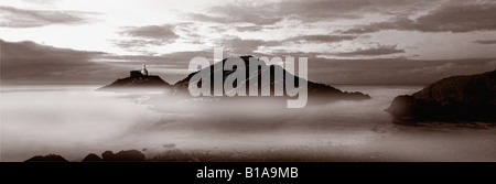 Una vista panoramica di mumbles faro in seppia. In primo piano è un po' di nebbia e appena visibile è il litorale. Foto Stock