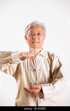 Un senior adulto giocando Tai Chi Foto Stock