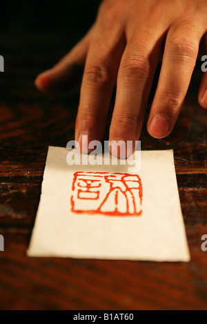 Cina,man's mani toccano tradizionale stampa chop,close-up Foto Stock